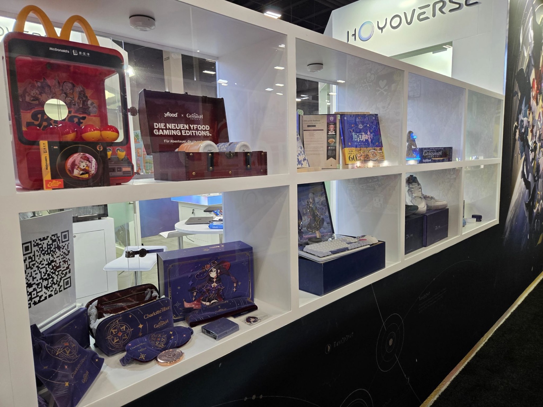 HoYoverse booth display shelves with McDonald's, yfood, and Charlotte Tilbury collaboration merchandise from Genshin Impact.