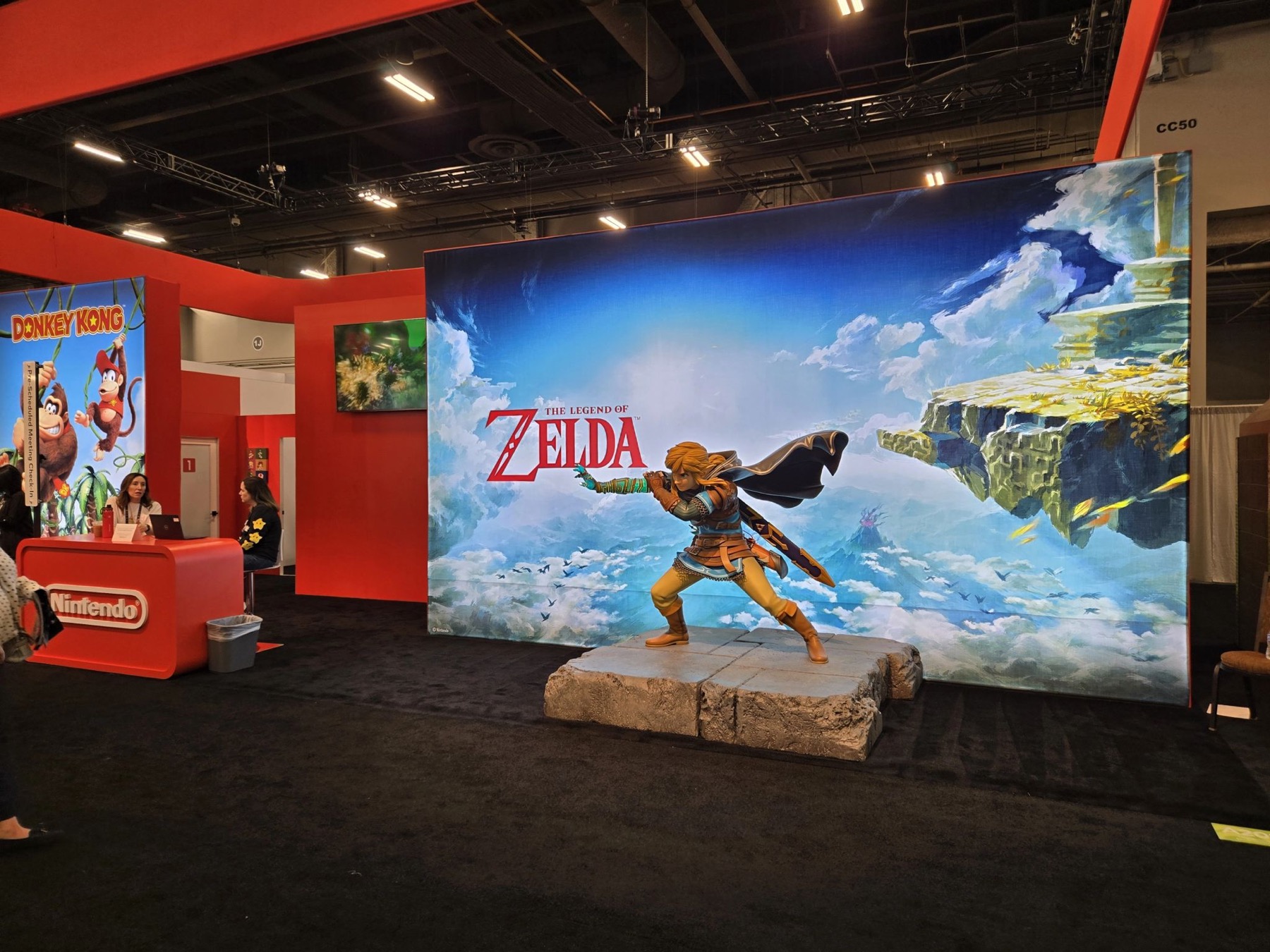 Nintendo booth featuring a large Zelda mural with a Link statue standing in front of it.