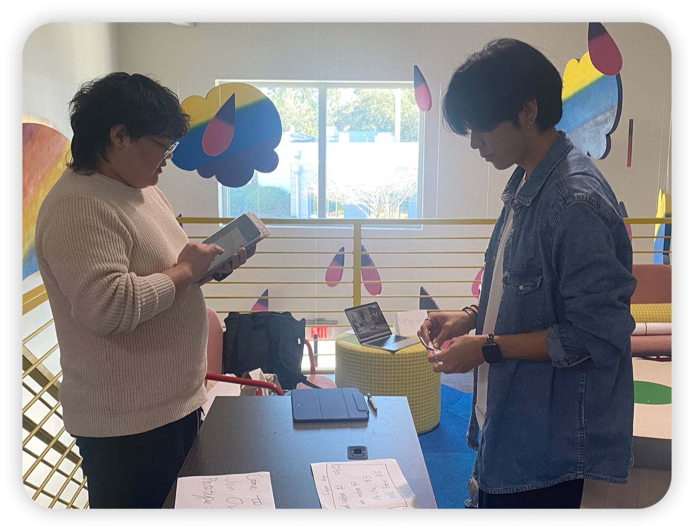 Participant tapping the POS tablet with designer observing